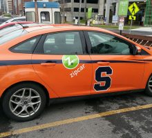 One of the Zipcars in service at Syracuse University has an orange graphic wrap, complete with the Syracuse block