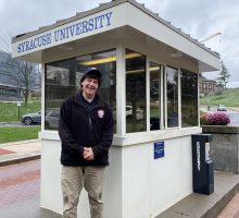 Man Standing Outside of Parking Booth